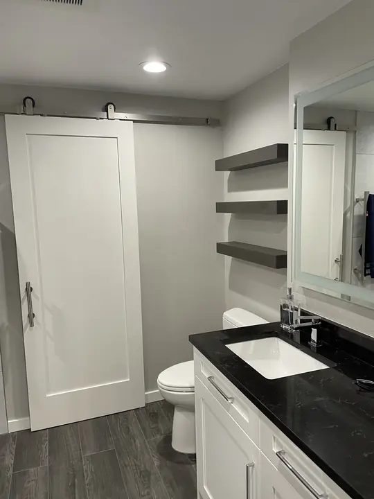 Black-top vanity, floating shelves and sliding barn door