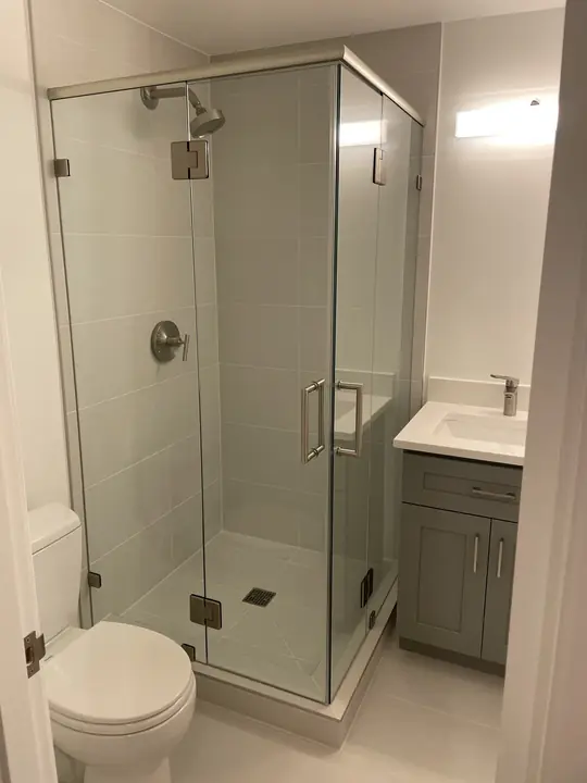 Frameless glass corner shower in a compact bathroom