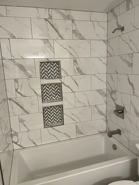 Marble tub surround with three chevron-tile niches