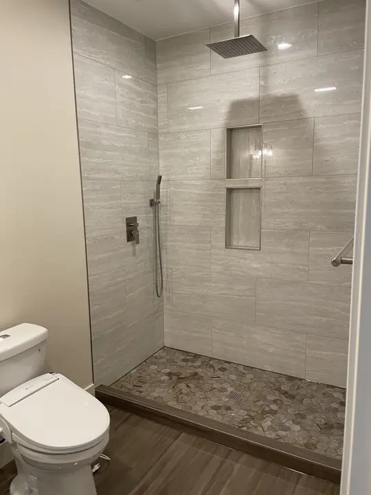 Walk-in shower with stacked niches and pebble floor