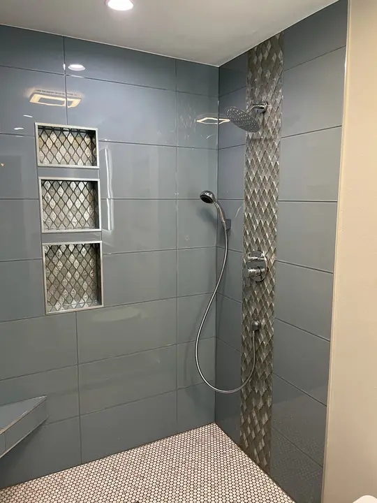 Blue glass-tile shower with three lit niches