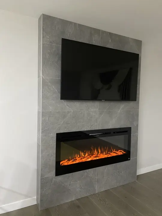 Floor-to-ceiling gray tile fireplace surround with TV