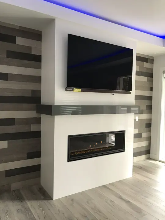 Media wall with linear fireplace, wood-look tile and cove LED