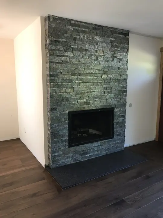 Stacked-stone fireplace with granite hearth