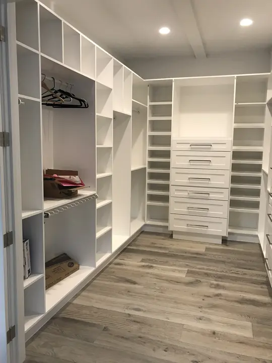 Walk-in closet with shoe shelves and drawer tower