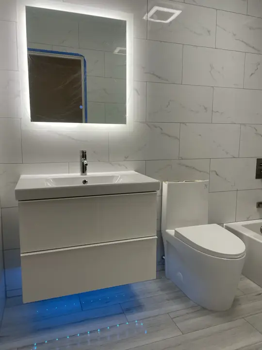 Floating vanity with blue under-glow and backlit mirror