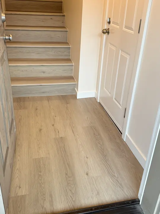 Plank flooring through a hallway with matching stair treads