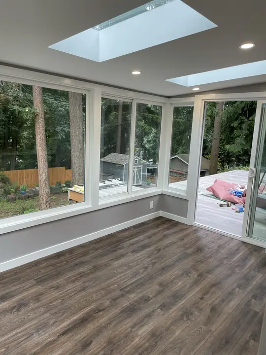 Sunroom with plank flooring and skylights