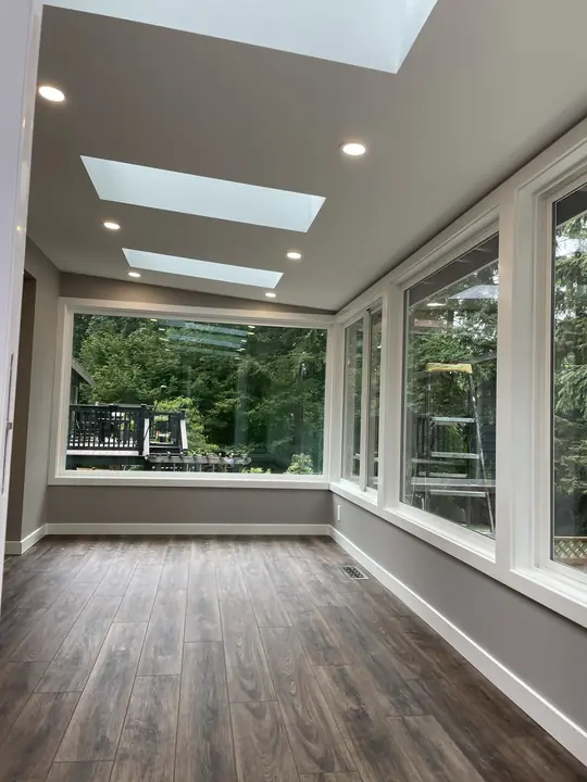 Sunroom with continuous plank floor and wall of windows
