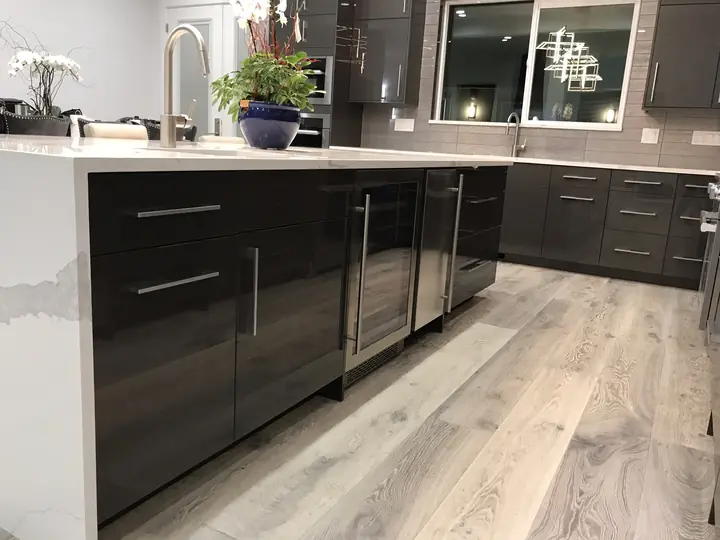 Dark gloss island with quartz top and wide-plank floor