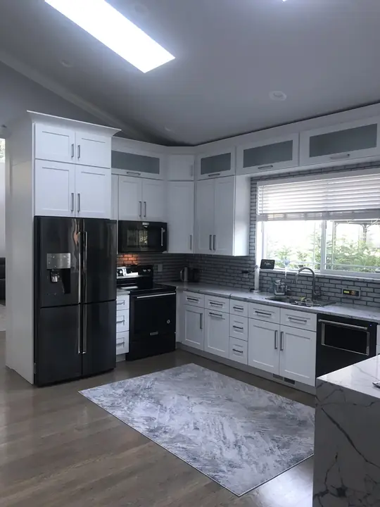 Vaulted white kitchen with skylights and black stainless appliances