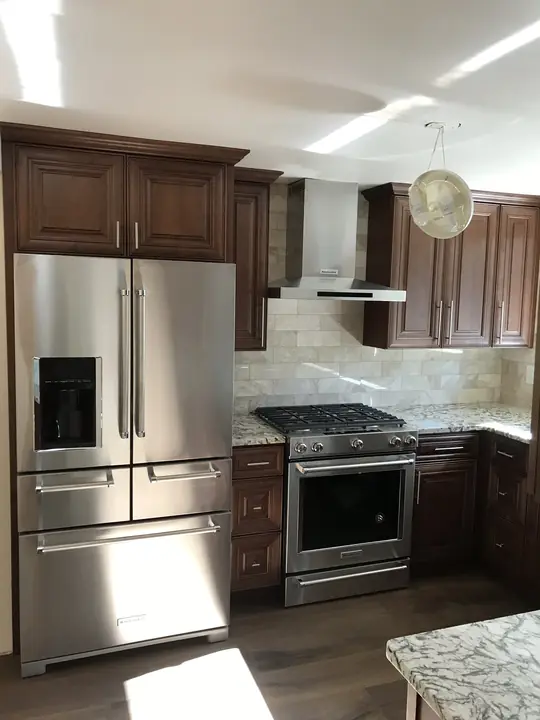 Walnut-stained kitchen with stone backsplash and stainless range