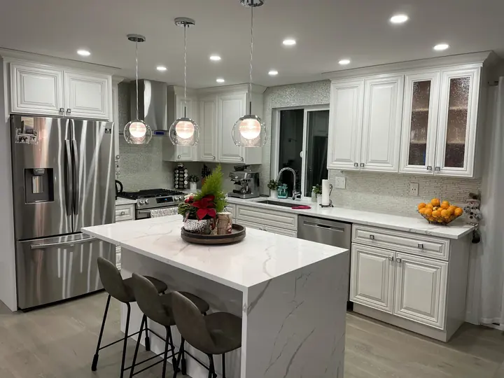 Classic white kitchen with quartz island and glass pendants
