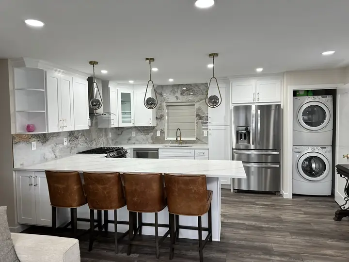 White kitchen with marble-look backsplash and island seating