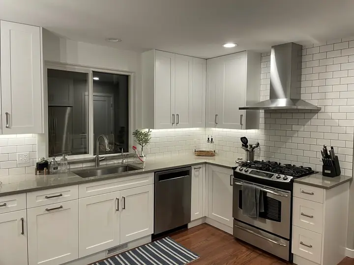 White kitchen with subway tile and chimney hood