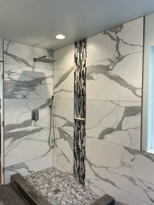 Large-format marble shower with vertical glass mosaic strip