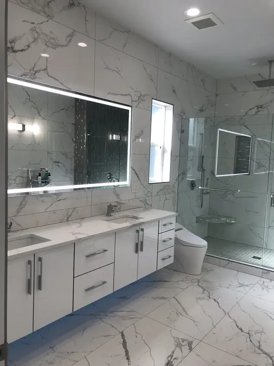 Marble-look bathroom with backlit LED mirror and floating double vanity