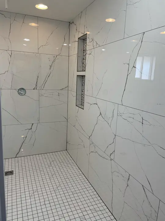 Floor-to-ceiling marble walk-in shower with tall niche