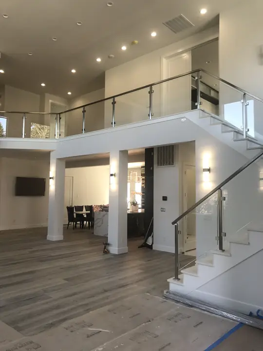 Open foyer with glass-railed staircase and wide-plank floor