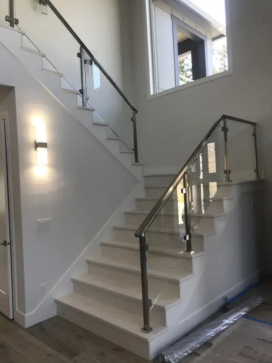 White staircase with stainless and glass railing