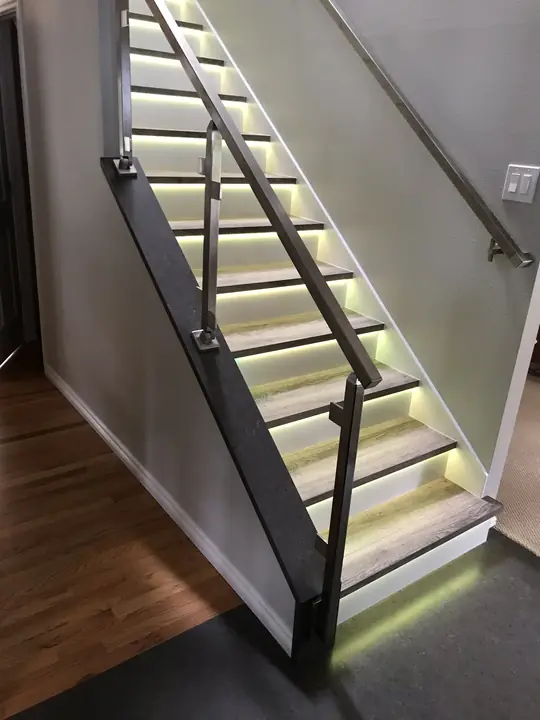 Staircase with lit treads and steel railing
