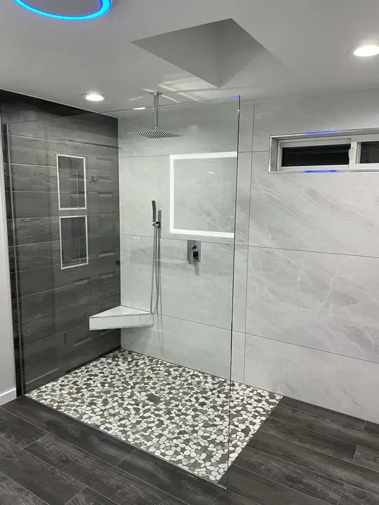 Walk-in shower with river-pebble floor and floating bench