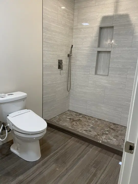 Walk-in shower with stacked niches and pebble floor