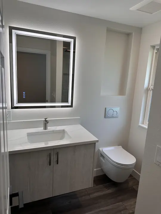 Floating vanity, wall-hung toilet and backlit mirror