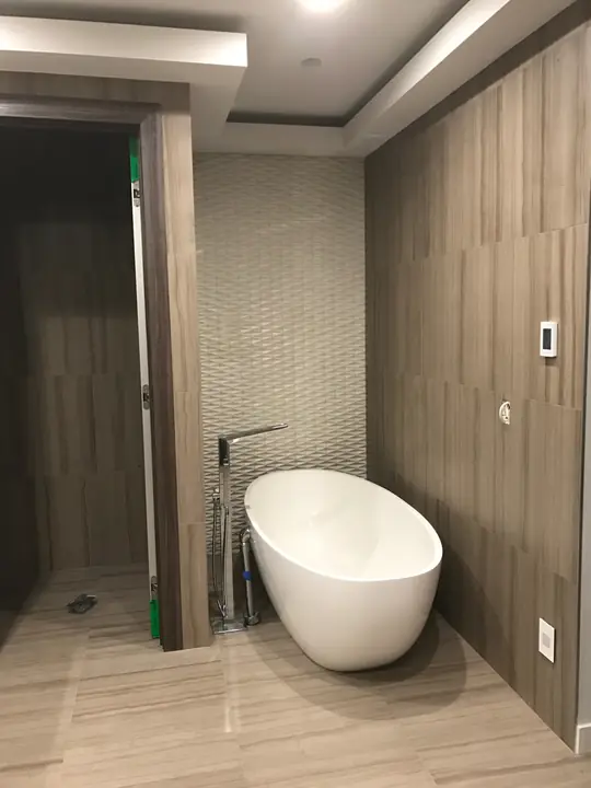 Freestanding tub framed in wood-look porcelain tile