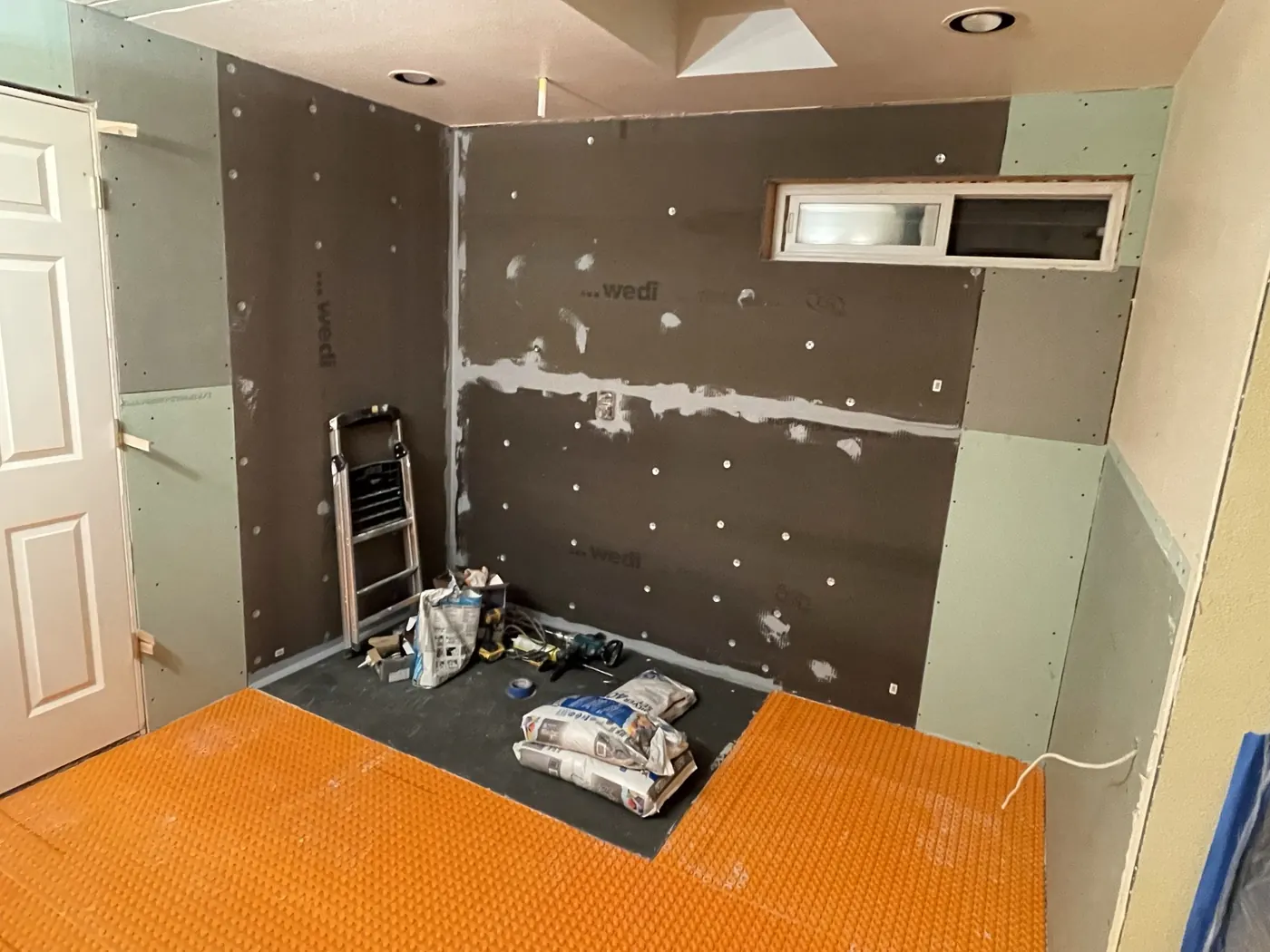 Schluter membrane installed on floor and walls before tile